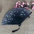 Classic black folding fan featuring white flower and butterfly patterns with black tassel - No.15 Black White Flower Butterfly
