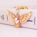 Portachiavi aquila dorata con cristalli scintillanti e strass su base di libro bianco - Oro Con Strass AB
