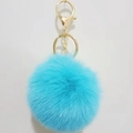 Close-up of bright blue 8cm faux rabbit fur pom pom keychain with gold metal lobster clasp - Lake Blue