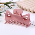 Pink matte hollow hair claw clip shown in a minimalist setting with soft lighting - Pink Frosted / 9.5CM