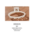 Elegant large pearl claw clip for women featuring cream white beads on a wooden background - Ellipse