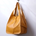 Detail of ginger yellow leather tote bag featuring a front pocket and soft lychee texture - Yellow