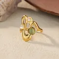 Golden wave adjustable ring with opal stones on a textured aesthetic background - Wave Cat's Eye Stone Style / Gold