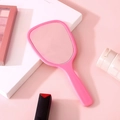 Elegant handheld makeup mirror in soft pink finish with a minimalist ergonomic handle - Pink