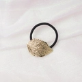 Detailed view of a gold leaf charm on a black hair tie over silk fabric background - Relief Leaf (6) / Gold