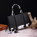Bohemian black shoulder bag featuring cow print faux leather straps and a woven texture - Large Black (Cow Print)