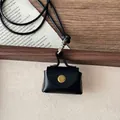 Macro detail of a vintage black leather pendant pouch with a brass button on wood - Black Mini Envelope Bag (11#)