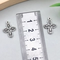 Dettaglio macro di ciondoli a croce in argento retrò con motivi a rilievo accanto a un righello - Croce Argento Antico 13x19mm
