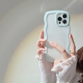 Close-up of light blue wave border phone case with transparent back held by a model - Light Blue Zircon