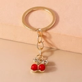 Portachiavi con ciliegia rossa brillante, anello dorato e fiocco di strass eleganti - Ciliegia con Perle e Fiocco