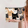 Gros plan d'une main tenant une pochette en toile avec divers motifs de têtes de chaton - Têtes de Chats Kawaii Imprimé Partout (jiaying0025)