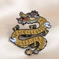Close-up of golden enamel dragon brooch featuring intricate white clouds and brown mane - Auspicious Dragon 3 (Golden)
