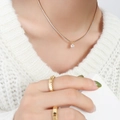Elegante 18k vergoldete Titankette mit Zirkonia-Anhänger an einem weiblichen Modell - Gold