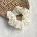 White fabric scrunchie with yellow polka dots on a natural straw tray background - White with Yellow Dots