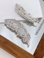 Elegant silver feather brooch with sparkling zircons reflected on a glass surface - Silver Color Clear Zirconia