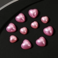 Close-up of pink pearlescent 3D heart-shaped charms for nail art and phone cases - Mixed Sizes / Pink