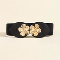 Close-up of golden metal flower buckle on a black elastic waist belt for women - Black