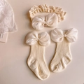 Detailed shot of baby socks and lace headband set with large cream satin bows - (Off-white) Silk Finish Bow Set