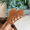 Dettaglio di un fermaglio per capelli marrone lucido con elegante design a osso di drago - Arancione Sandalo