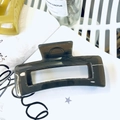 Detailed close-up of a dark translucent rectangular hair claw clip on a white book - 12.5CM / Dark Gray