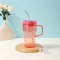 Detail of a large capacity plastic straw cup with handle on a wooden coaster - 20oz / Orange