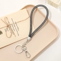 Detail of black mesh wrist lanyard with silver metal ring and lobster clasp on a tray - Rhinestone Mesh Pendant (Clasp) / Black