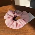 Detailed macro of pink cotton linen hair scrunchie with floral button on wooden surface - Barbie Pink Button Scrunchie
