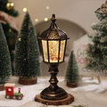 Macro view of bronze Christmas lantern featuring a snowy scene with LED warm lighting - Boy Style