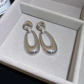 Close-up of silver hollow oval earrings with micro-paved zircons in a jewelry box - Oval Hollow Style / Silver
