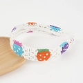 Detailed close-up of white crochet headband with colorful floral knit patterns - White Strawberry