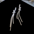 Detailansicht der funkelnden Silber-Quastenohrringe mit Kristall-Strass auf schwarzem Samt - Silberne Geknotete Schlangenkette Quaste (925 Sterling Silver Earring Post)