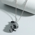 Gothic half-face skull necklace in vintage silver finish on a display stand - Antique Pewter
