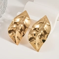 Macro detail of leaf-shaped gold earrings with textured hammered finish and metallic luster - Gold Leaf (925 Silver Pin)