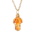 Macro detail of wire-wrapped orange agate mushroom pendant on a delicate gold chain - Agate
