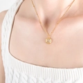 Collana vintage dorata con ciondolo quadrato in pietra smeraldo e catena a satellite su modella - Collana Oro Zircone Bianco