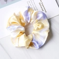 Detailed view of yellow and purple tie-dye satin silk scrunchie on marble background - Tie Dye Yellow