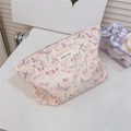 Dettaglio di una trousse per il trucco in cotone floreale con cerniera ed etichetta - Floreale Viola