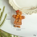 Hand-painted gingerbread girl resin ornament with a red bow and white icing details - Yellow Bow Gingerbread Man