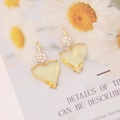 Detailed view of yellow heart-shaped earrings with zircon accents and gold plating - Yellow