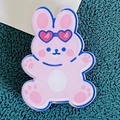Cute pink acrylic bunny badge with heart sunglasses on green fabric background - Happy Rabbit