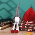 Weihnachtswichtel mit gestreiften Beinen auf einem britischen Vintage-Koffer als Dekoration - Grau