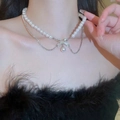 Double-layer pearl necklace with a sparkling diamond bow pendant on a female model - Alloy/Faux Pearl/Rhinestone / Double Layer Bowknot Pearl Necklace