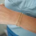 Detail of 18K gold-plated stainless steel paperclip and bead chain bracelets on a wrist - Paperclip And Bead Layered Style (Style 02)