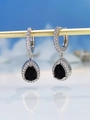 Detailed macro view of pear-shaped black crystal earrings with silver diamond pavé setting - Black