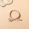 Detail of beige braided hair tie featuring a twisted rope design and gold tipped bow accent - Braided Style / Beige