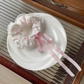 Detail of floral scrunchie with lace edges and pink gingham ribbons in a ceramic dish - Lace Trim Pink