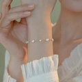 Elegant gold chain bracelet featuring white pearls of various sizes on a woman's wrist - Gold Fine Chain Multi-Pearl Design (MY36323)