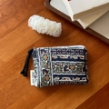 Detail of bohemian mini pouch with floral print on a rustic wooden background - Navy Orange Brown Paisley