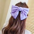 Elegant purple satin chiffon oversized bow hair clip worn on wavy brown hair back view - Purple
