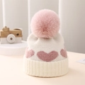 Detalle de gorro de punto para bebé en color marfil con corazones rosas y pompon de piel - Talla Única 0-12 Meses / Blanco